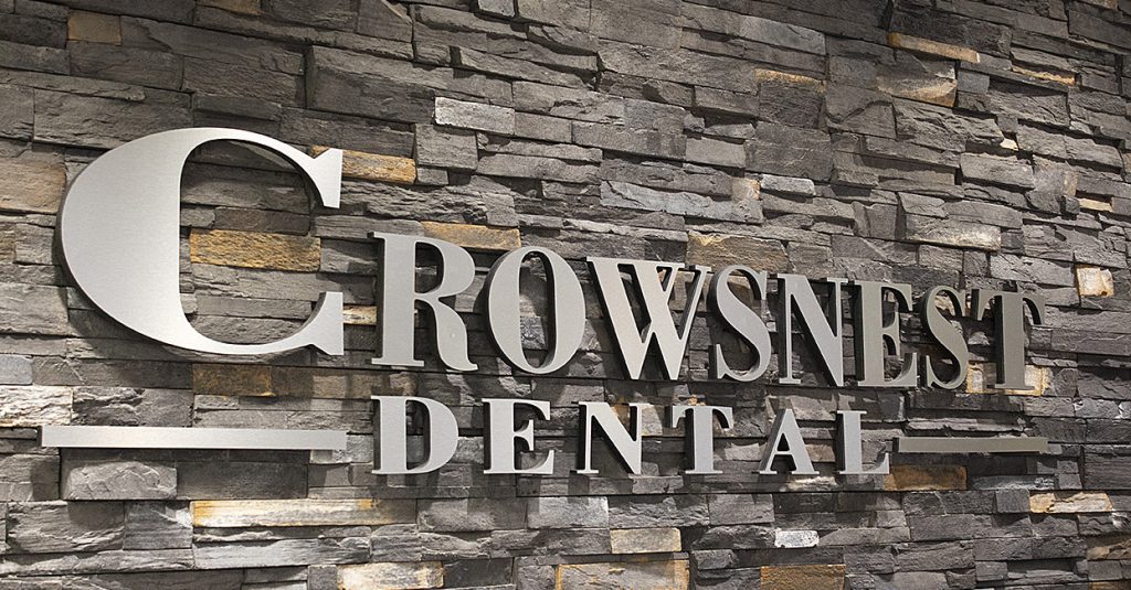 Metal Crowsnest Dental letters on a stone wall